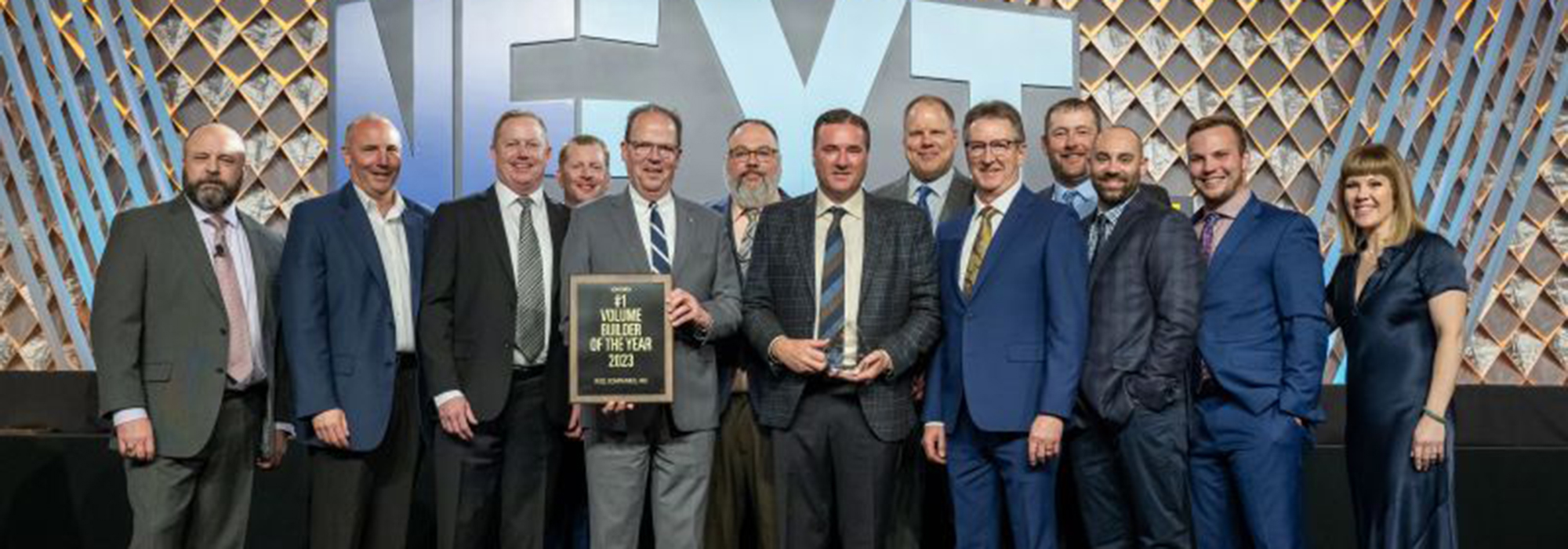 Line of professionals at formal awards banquet accepting award on stage