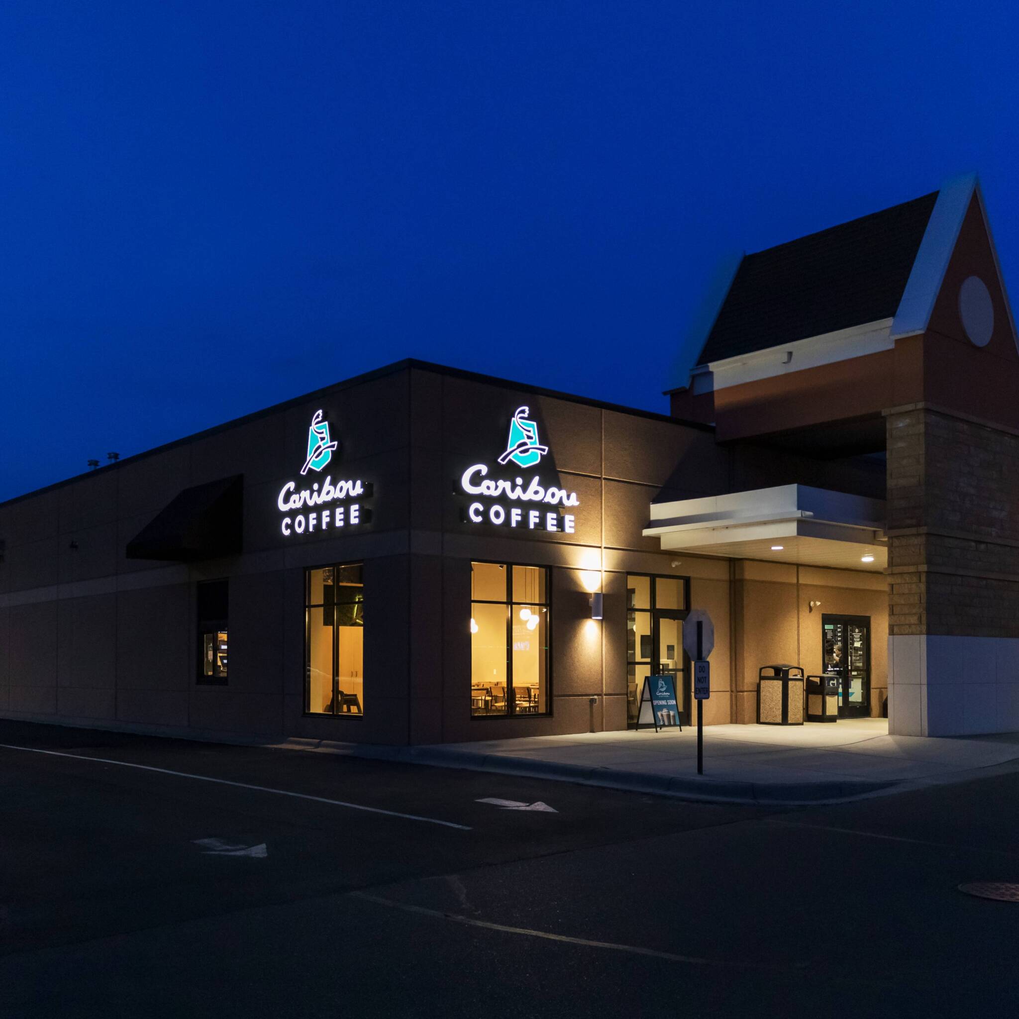 Lit coffee shop building exterior at night