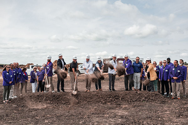 Line of professional construction workers at ground breaking
